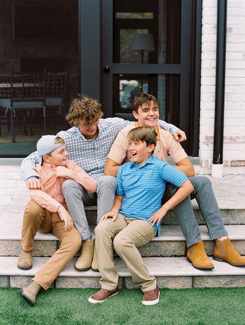 Dr. Andy Turner's four son's in a group sitting on steps in the outdoors