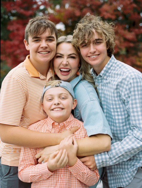Dr. Andy Turner's wife and three sons smiling in a group hug outdoors